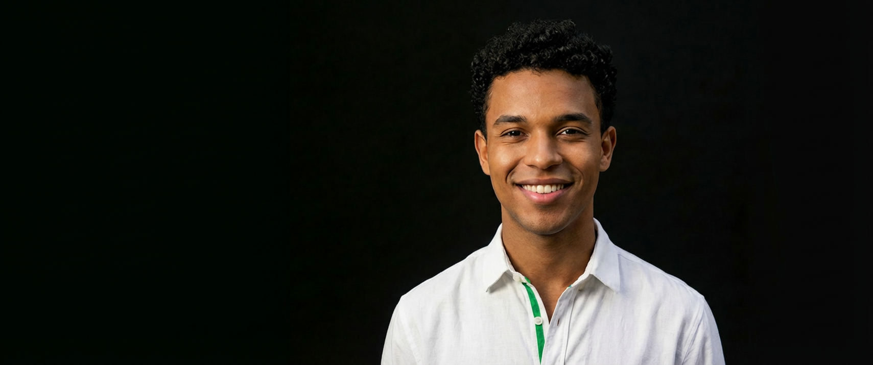 Uma mulher com cabelos loiro e curto, olhando para frente. Ela veste uma blusa branca com camiseta da cor verde neon.